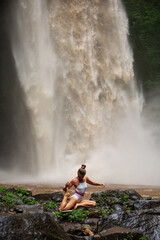 Sticker - Beautiful woman doing yoga near a waterfall in Bali