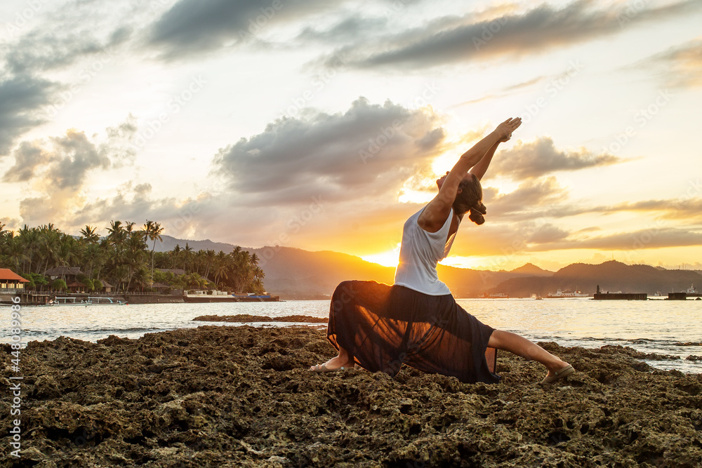Woman doing yoga by the sea - obrazy, fototapety, plakaty 