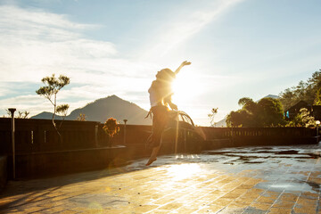 Wall Mural - Woman doing yoga at dawn near a volcano on the island of Bali