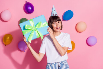 Canvas Print - Portrait of attractive curious cheerful girl holding giftbox congrats air balls flying isolated over pink pastel color background