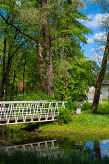  A white wooden bridge in the Poltsamaa city park on a sunny summer day.