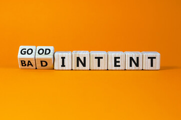 Good or bad intent symbol. Turned wooden cubes, changed words 'bad intent' to 'good intent'. Beautiful orange table, orange background. Business, bad or good intent concept. Copy space.