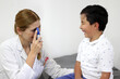 © Arlette - Female pediatrician doctor examining a 7-year-old Latino boy in her office