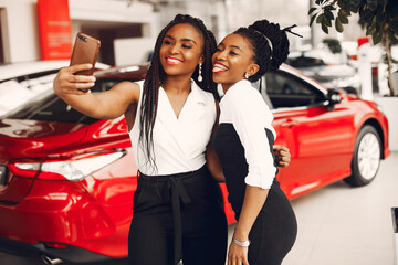 Two stylish black women in a car salon