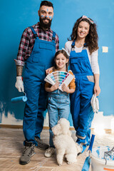 Wall Mural - Happy family renovating their home. They are painting a wall together.