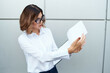 © SHOTPRIME STUDIO - Business woman with documents in hands on the street near the building