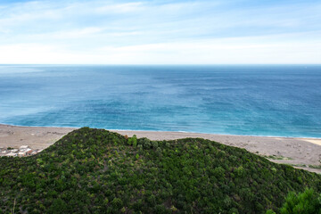 Wall Mural - Aerial view of green mountain and blue sea, aerial view of sandy beach, blue sky and white clouds, tropical area for vacation and camping in the Mediterranean sea, Jijel, Algeria, Africa.