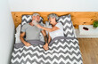 © Alessandro Biascioli - Happy senior couple laughing together while lying in bed below blankets - Elderly lifestyle and love relationship concept