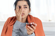 © SHOTPRIME STUDIO - woman covered with a blanket sits at the table treating a cold at home
