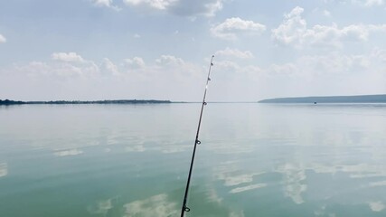 Wall Mural - spinning or fishing rod on background of lake during day