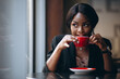 African american woman drinking coffee in a bar