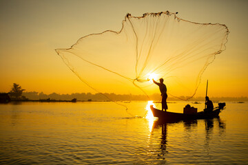 fisherman throwing his net at sunrise