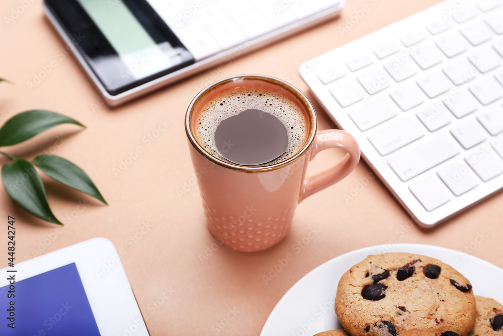 Cup of coffee, keyboard and cookies on color background