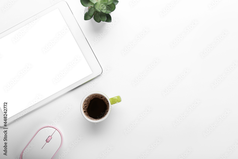 Cup of coffee, tablet computer and PC mouse on light background