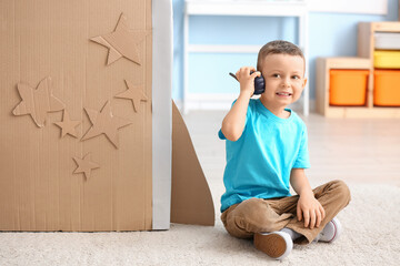 Wall Mural - Cute little boy playing with radio transmitter at home