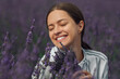 Young woman with lavender bouquet on violet flowers field background