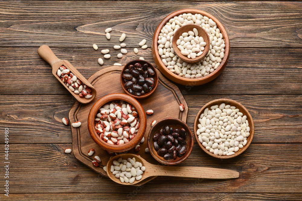 Composition with different types of beans on wooden background