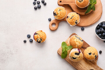 Wall Mural - Composition with tasty blueberry muffins and berries on light background