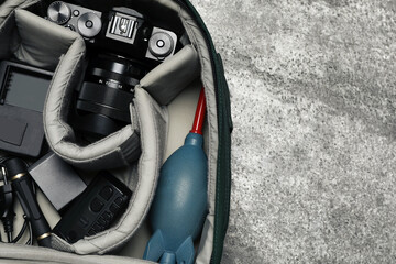 Wall Mural - professional photography equipment in backpack on grey stone table, top view. space for text
