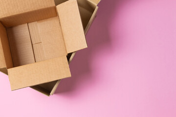 Wall Mural - Empty open cardboard boxes on light pink background. Top view, copy space