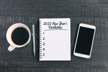 Wall Mural - 2022 New Year's Resolutions Text on Note Pad with smart phone and a cup of coffee