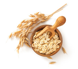 Wall Mural - Oat flake in wooden bowl with spoon and spikelets of oats isolated. Bowl of oats on white background. Top view of oat.