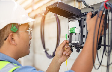 an internet technician is repairing or maintaining a fiber optic connection by opening a fiber optic
