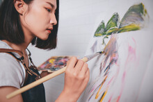 Asian Woman Artist Painting Picture With Blank Canvas Side View, Using Paint Brush And Colour Pallets Having Fun Creativity Activity Occupation Hobby Concept, Creative Thinking Imagination Visual