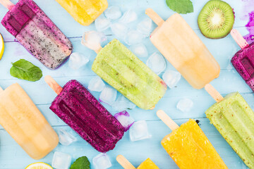 Poster - Healthy Whole Fruit Popsicles with Berries Kiwi watermelon cantaloupe on wooden vintage table