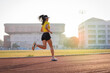 © EduLife Photos - A young Asian woman athlete runner jogging on running track in city stadium in the sunny morning to keep fitness and healthy lifestyle. Young fitness woman runs on stadium track. Sport and recreation