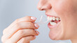 © Михаил Решетников - Caucasian woman brushing teeth with toothpick with dental floss on white background.