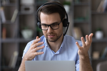 Wall Mural - virtual helpdesk. young man in eyewear and wireless headset call center agent give technical support