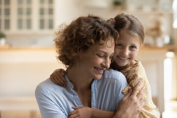 Wall Mural - Head shot portrait happy caring mother and adorable little daughter hugging enjoying tender moment, smiling young mom with preschool kid child feeling love, good family relationship concept