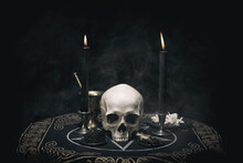 Witchcraft Composition With Burning Candles, Human Skull, Bones, Herbs And Pentagram Symbol. Halloween And Occult Concept, Black Magic Ritual. 