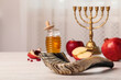 Shofar and other Rosh Hashanah holiday attributes on white wooden table indoors
