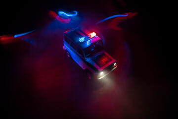 Wall Mural - Police car chasing a car at night with fog background. 911 Emergency response police car speeding to scene of crime. Selective focus