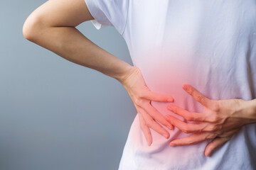 adult female with muscle pain on gray background. Elderly woman having back body ache due to Piriformis Syndrome, Low Back Pain and Spinal Compression. Sports injuries and medical concept