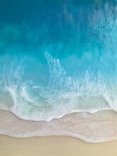 Top View On Sea Wave With White Foam And Light Beige Sand. Fluid, Pour Drawing Of Epoxy Resin. Summer Sunny Beach Painting, Seascape, Blue, Azure, Turquoise Color Of Water, Shore. 