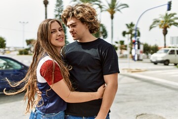 Young caucasian couple smiling happy and hugging at the city.