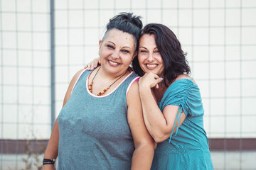 Two adult twin sisters hugging. Different styles