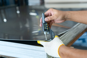 the photo shows how to measure how thick of the metal sheet by using digital thickness gauge.