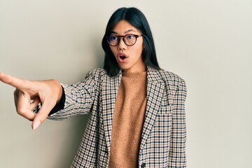 Sticker - Young chinese woman wearing business style and glasses pointing with finger surprised ahead, open mouth amazed expression, something on the front