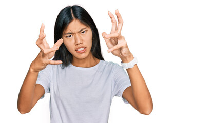 Canvas Print - Beautiful young asian woman wearing casual white t shirt shouting frustrated with rage, hands trying to strangle, yelling mad