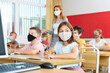 © JackF - Portrait of schoolgirl in protective face mask who writing exercises at lesson in primary school