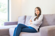 © siraphol - Portrait beautiful young asian woman relax smile on sofa