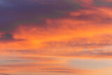 Fototapeta Na sufit - Colorful dramatic sky at sunset with layered rain clouds of purple and gold color