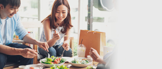 cheerful multiracial friend smiling and eating healthy food in a restaurant, group of happy friend concept