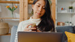 © tirachard - Sick young asian woman hold medicine sit on couch video call with laptop consult with doctor at home. Girl take medicine after doctor order, quarantine at house, Social distancing coronavirus concept.