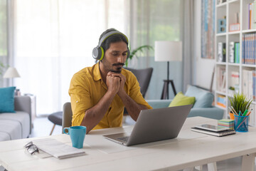 Man connecting with his laptop and wearing headphones