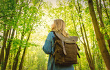 Fototapeta Las - Young woman with backpack in a mixed forest Beskidy in Poland in spring time.
